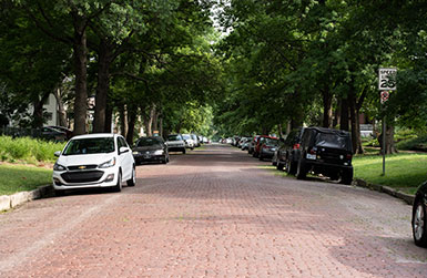 Brick residential street with vehicles parked